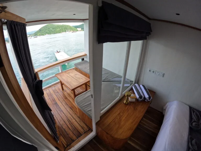 Interior of a cabin aboard the Lanakila phinisi with ocean views. — Lanakila