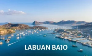 Aerial view of Labuan Bajo harbor with boats and islands in the background.